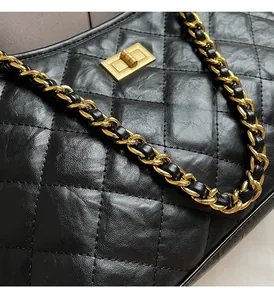 Detailed close-up of vintage quilted leather texture and gold turn-lock on the tote bag