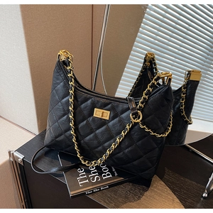 Detail of black quilted leather tote with gold chain strap and metallic twist lock