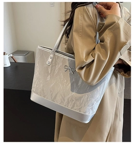 Vue détaillée du grand sac cabas argenté avec texture froissée et nœud métallique