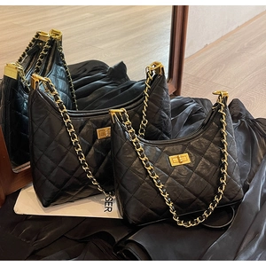 Detail view of black quilted leather tote bags in two sizes with gold chain and turn-lock
