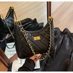 Detail of quilted leather tote with gold chain strap and elegant metallic turn-lock closure