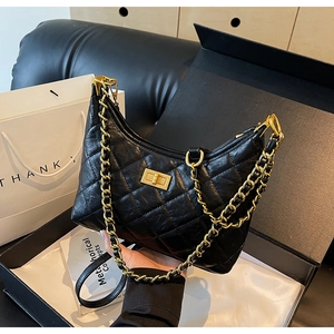 Detailed view of quilted leather tote bag with gold chain strap in premium gift packaging