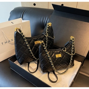 Detail of black quilted leather tote bag with vintage gold clasp in luxury gift box