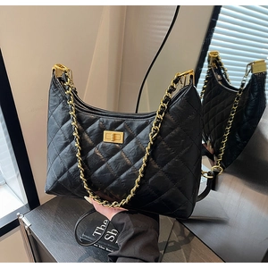 Detail of black quilted hobo bag with gold metal chain and rectangular turn-lock closure