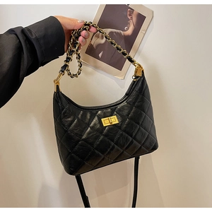 Detail of vintage quilted leather tote with gold metal chain and turn-lock closure