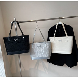 Trois sacs cabas plissés en noir, argent et crème avec nœuds métalliques et bandoulières fines
