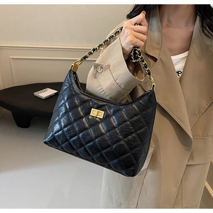 Close-up of black quilted leather hobo bag with gold metal twist lock and chain strap