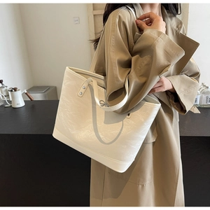 Détail du sac cabas blanc crème avec texture plissée et boucle nœud argentée
