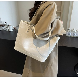 Détail d'un sac cabas blanc avec texture marbrée et fines bretelles élégantes
