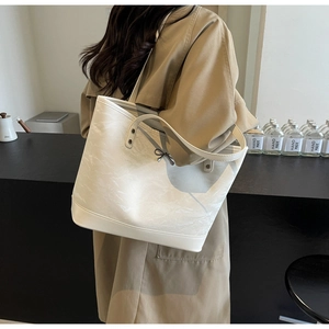 Détail du grand sac cabas crème avec texture froissée et petit nœud décoratif élégant
