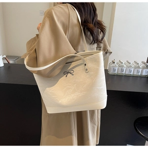 Détail du grand sac cabas crème avec texture marbrée et boucle de nœud en métal noir