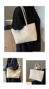 Macro detail of the creamy white faux leather tote bag with lychee texture and metal logo