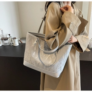 Détail du sac cabas argenté métallisé avec texture froissée et nœud sur l'épaule