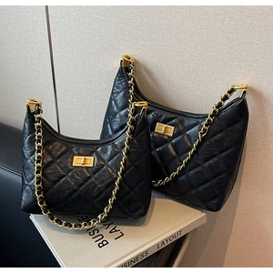 Detail of black quilted chain bags with gold twist locks and leather woven straps