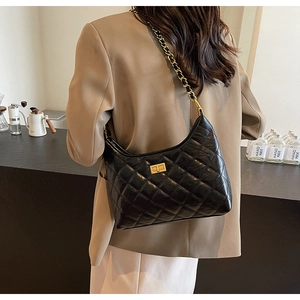 Close-up of quilted black leather hobo bag with gold chain strap and square turn-lock