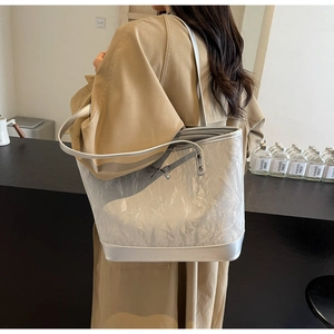 Détail du sac cabas argenté avec texture métallisée froissée et fermoir à nœud élégant