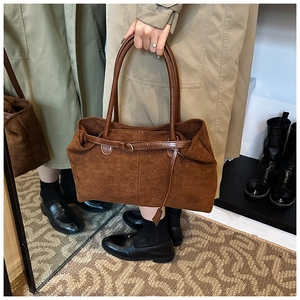 Detailed view of caramel brown frosted tote bag with thin leather handles in a lifestyle setting