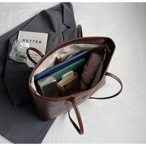 Top view of a large brown tote bag showing its spacious interior with tablet and umbrella