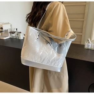 Détail du sac cabas argenté métallisé avec texture froissée et nœud sur l'épaule