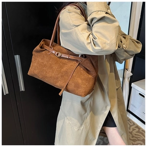 Brown matte tote bag styled on model wearing a khaki trench coat for a retro commute look
