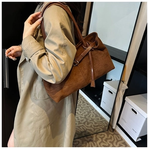 Brown frosted leather tote bag detail with decorative side straps and retro shoulder straps
