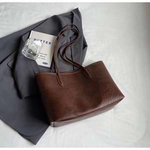 Detailed view of the brown vintage leather texture and durable strap on this large tote bag