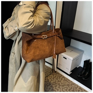 Detail showing vintage caramel suede tote bag with slim straps and metal buckle accent