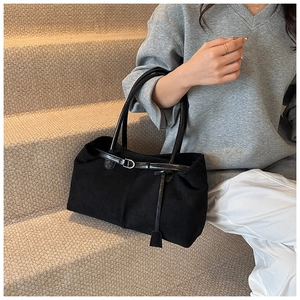 Detail of matte suede texture and leather contrast on a large black commute tote bag