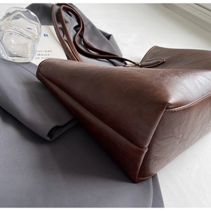 Detailed side view of deep brown vintage tote bag showing premium PU leather texture