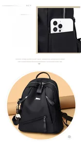 Detail of black nylon backpack side pocket with quilted pattern and smartphone storage