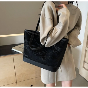 Détail du sac cabas noir avec texture plissée en PU et base en cuir synthétique lisse