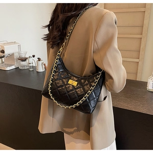 Quilted black leather shoulder bag detail with gold chain strap and twist-lock closure