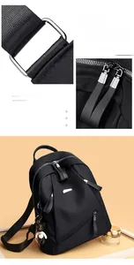 Close-up of durable hardware ring and dual zipper pulls on black leather backpack