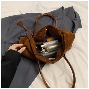 Macro shot of spacious brown suede tote bag interior showing large capacity for cosmetics