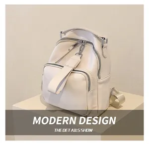 Detail of a beige PU leather backpack featuring litchi texture and silver hardware zippers