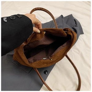 Detail view of large corduroy tote bag showing magnetic clasp and brown lining