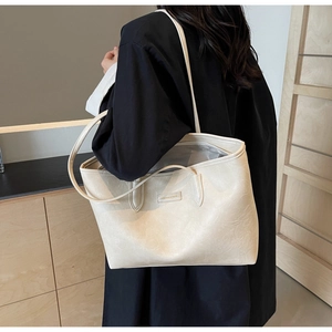 Detailed view of cream tote bag with leather texture and Fashion & Bags branding