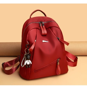 Close-up of red large capacity backpack with waterproof fabric and bear keychain