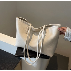 Detailed close-up of cream PU leather tote bag with Fashion and Bags embossed logo tag