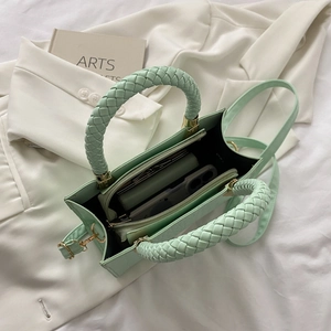 Close-up of mint green woven handle handbag showing interior compartments and PU texture