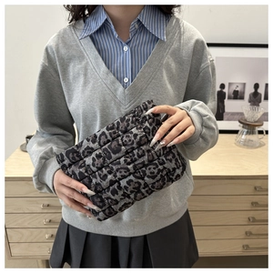 Detail of quilted leopard print clutch bag with soft texture and chic pattern