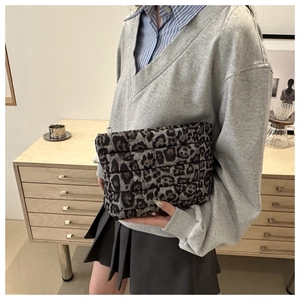 Detail showing quilted animal leopard print clutch bag with soft texture and zip closure