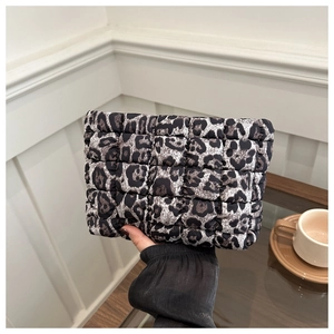 Detail of grey leopard print quilted clutch bag with soft padded texture and stitching