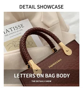 Detail showing brown crocodile pattern leather with braided handle and gold fashion text
