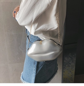 Chic silver mirror lip-shaped crossbody bag with gold chain strap shown on a model