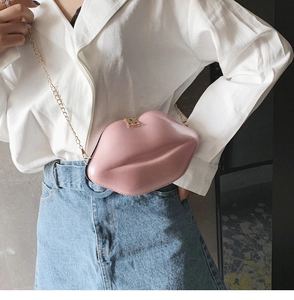 Detail of pink lip-shaped crossbody bag with glossy patent leather and gold chain