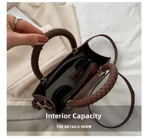 Internal capacity of brown vintage handbag showing mobile phone and woven handle detail
