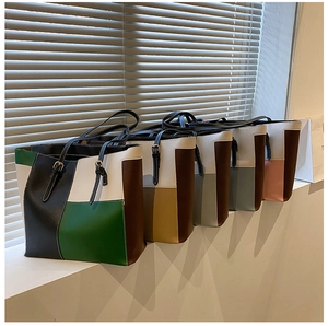 Macro detail of multi-color patchwork PU leather tote bags with elegant gold metal buckles
