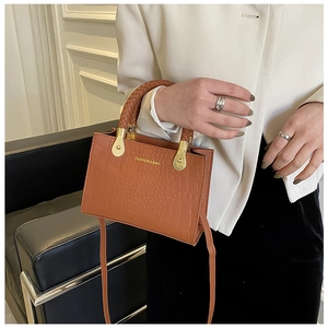 Brown crocodile embossed handbag with woven handle and gold fashion bag logo detail
