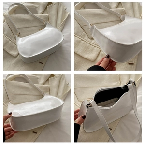 Detalles de un bolso de media luna blanco brillante con hebillas doradas y forro negro